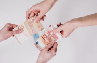 zwei Personen geben sich die Hand mit Euroscheinen