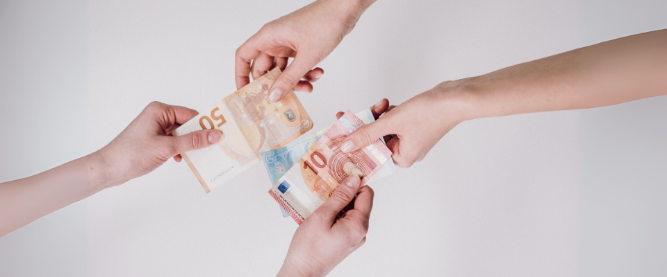 zwei Personen geben sich die Hand mit Euroscheinen